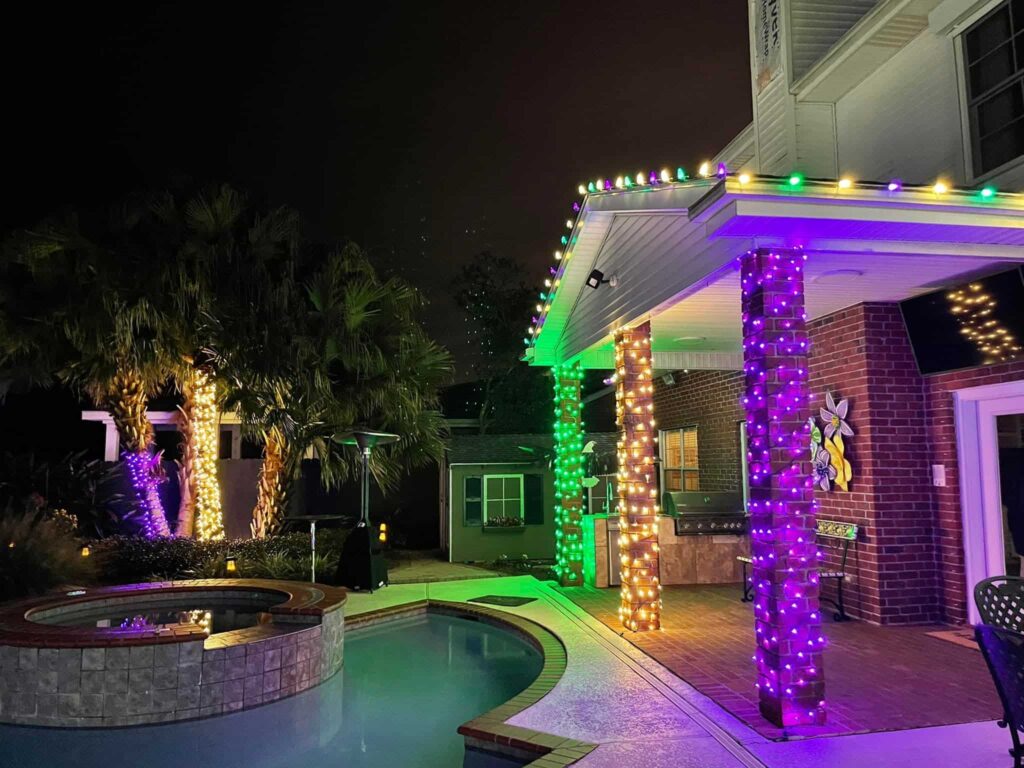 Poolside party with columns wrapped in green and purple lights