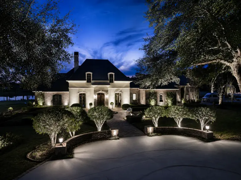 Bright white landscape lighting along a circular driveway and front entry